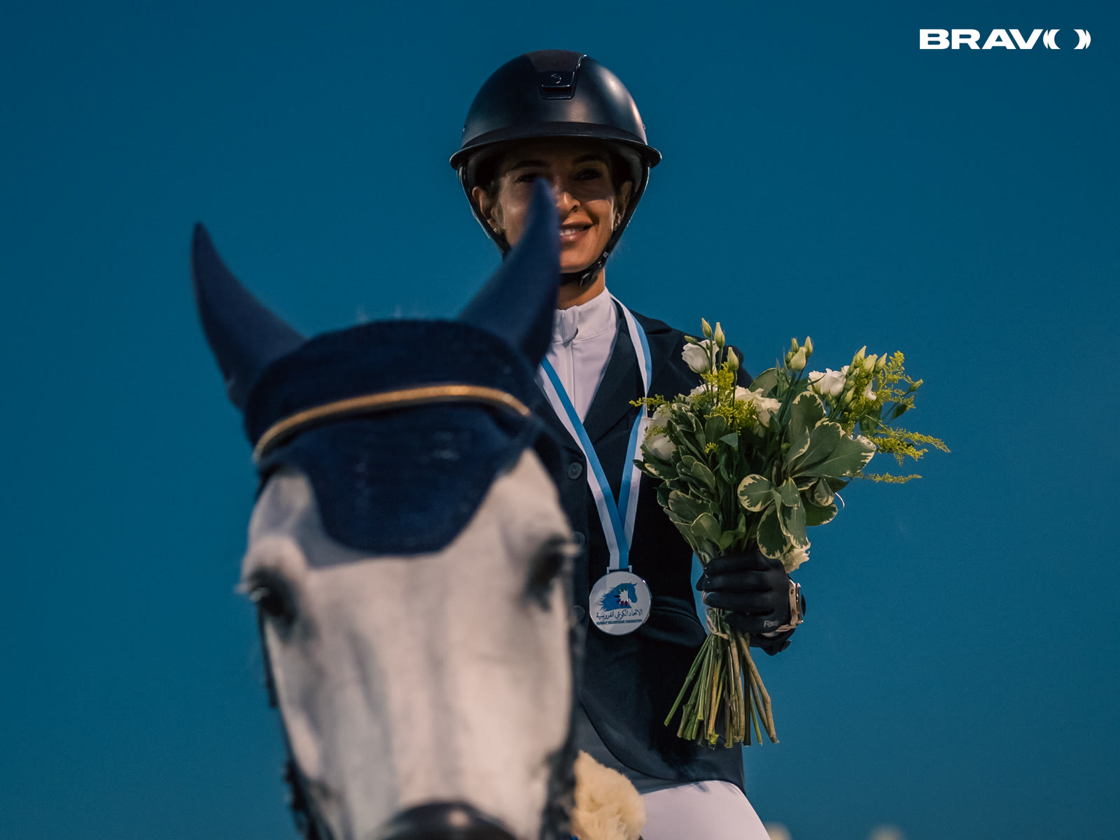 Equestrian champion on horseback with medal and bouquet